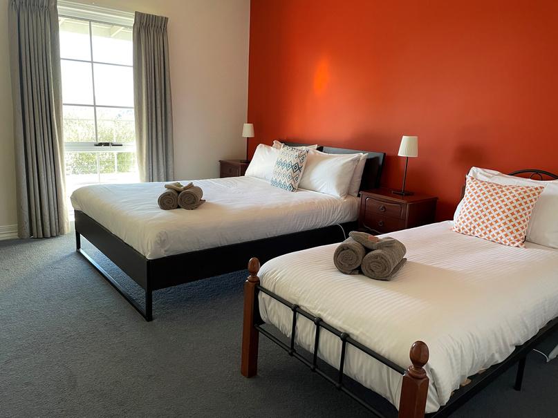 two beds in a room with orange walls
