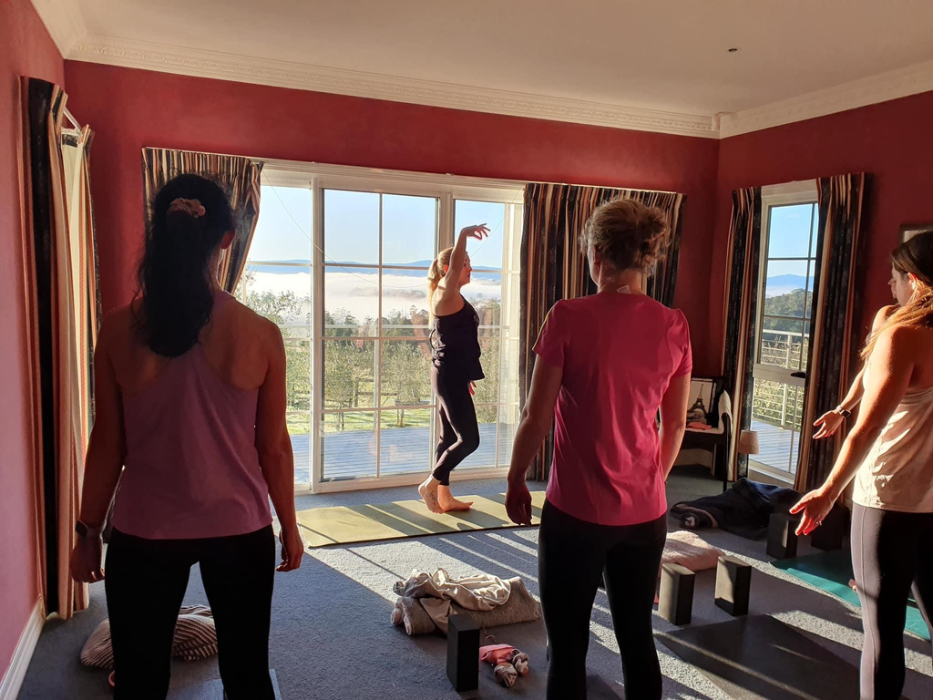 a group of people practicing yoga in a room with a view of the mountains